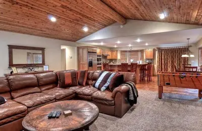 a living room with a brown leather couch and a table at Arctic Wolf at Summit Base - 4 Bedroom log cabin at the base of Snow Summit in Big Bear Lake