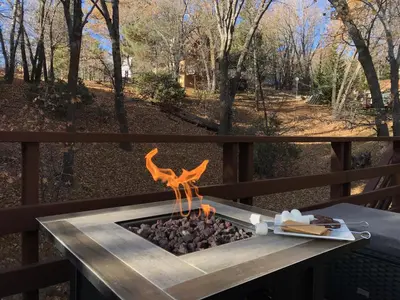 a fire pit on a deck with a view at Sprocket Hollow Treetop A-Frame Log Cabin in Cedar Glen