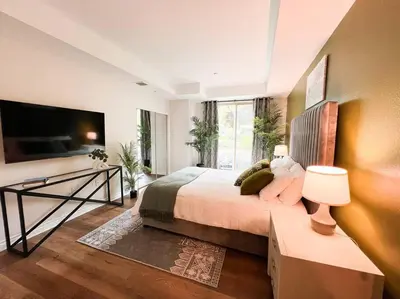 a bedroom with a large bed and a television at Cozy Apartment in Heart of Encino 104 in Encino