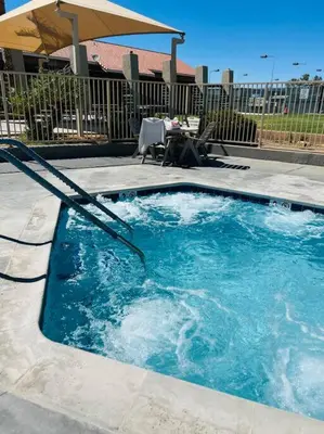 a swimming pool with a table and an umbrella at Silver Lakes Oasis with Resort Style Amenities in Helendale