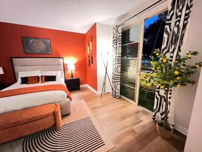 a bedroom with orange walls and a bed and a window at Beautiful 2 BD 3 Beds in Heart of Encino 105 in Encino