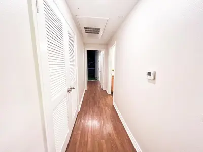 an empty hallway with white walls and wood floors at Beautiful 2 BD 3 Beds in Heart of Encino 105 in Encino
