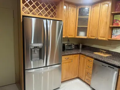 a stainless steel refrigerator in a kitchen with wooden cabinets at Emeric Ave in Simi Valley in Simi Valley