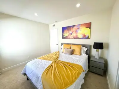 a bedroom with a bed with a yellow blanket on it at Family Paradise near Disneyland with Sparkling Pool in Del Prado Bolsa