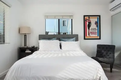 a bedroom with a white bed and a chair at Sunny Studio in the Heart of Venice Beach - #6 in Los Angeles