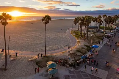 a group of people walking on the beach at sunset at Sunny Studio in the Heart of Venice Beach - #6 in Los Angeles
