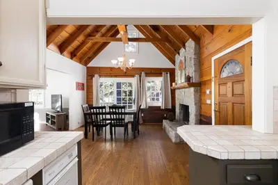 a kitchen and dining room with a table and a fireplace at Gingerbread Gardens in Twin Peaks