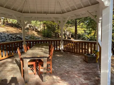 a wooden table and chairs on a patio at Gingerbread Gardens in Twin Peaks