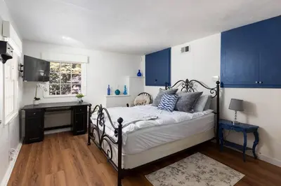 a bedroom with blue cabinets and a bed and a desk at Hideaway at Gingerbread Gardens in Twin Peaks