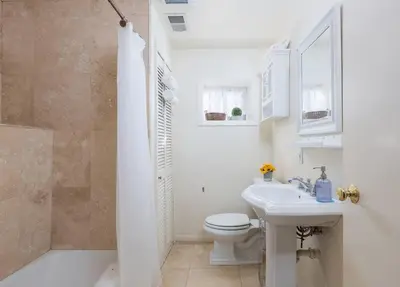 a white bathroom with a toilet and a sink at Hideaway at Gingerbread Gardens in Twin Peaks
