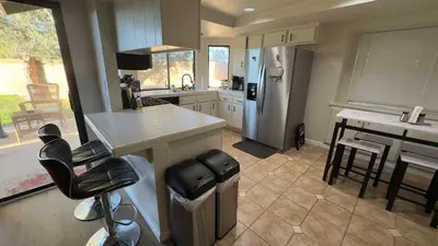 a kitchen with a counter and a sink and a refrigerator at Oasis Home near Rancho Vista in Quartz Hill