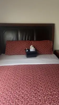 a bed with a black headboard and red pillows at Oasis Home near Rancho Vista in Quartz Hill