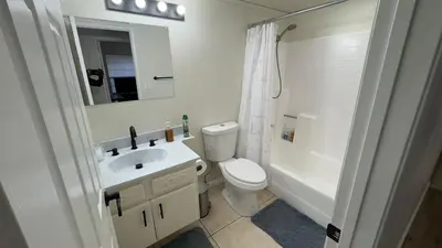 a bathroom with a toilet and a sink and a mirror at Oasis Hm near Rancho Vista- Shared Hm in Palmdale