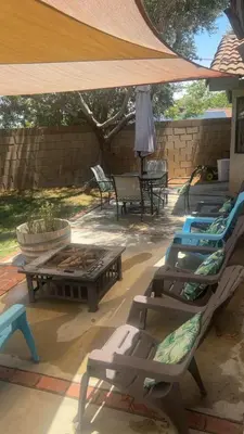 a patio with lounge chairs and tables and a tent at Oasis Hm near Rancho Vista- Shared Hm in Palmdale