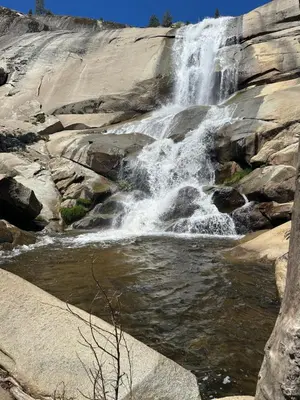 a waterfall on the side of a rocky mountain at Peppermint Falls Ranch in Ponderosa