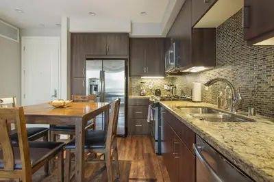 a kitchen with wooden cabinets and a wooden table at Charming 1BD with Pool and Free Parking in Los Angeles