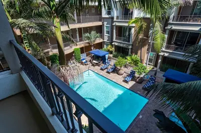 an apartment balcony with a pool and palm trees at Charming 1BD with Pool and Free Parking in Los Angeles