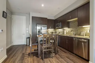 a kitchen with wooden cabinets and a table and chairs at Charming 1BD with Pool and Free Parking in Los Angeles