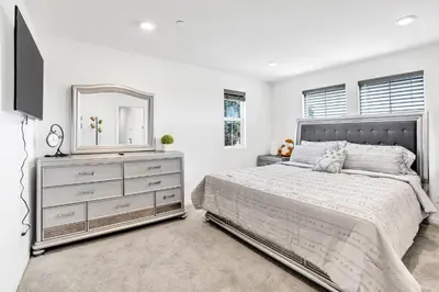 a bedroom with a bed and a dresser and a mirror at Charming Home Near Six Flags in Santa Clarita