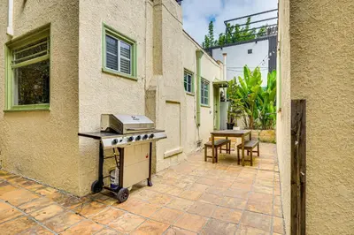 an outdoor patio with a grill and a table at Walk to Abbot Kinney Tranquil Cottage in Venice! in Los Angeles