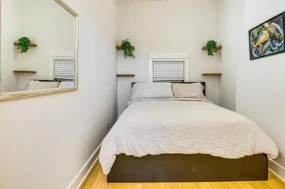 a bedroom with a bed and a mirror at Walk to Abbot Kinney Tranquil Cottage in Venice! in Los Angeles