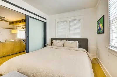 a bedroom with a large bed with white walls at Walk to Abbot Kinney Tranquil Cottage in Venice! in Los Angeles