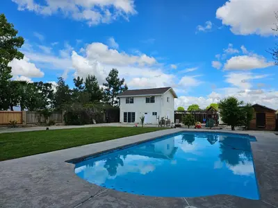 a swimming pool in front of a white house at Spacious 2 story 1 bedroom home with pool in Rio Bravo