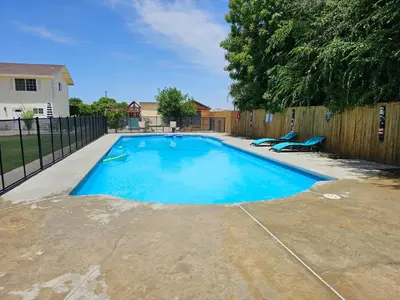 a swimming pool in a backyard with a fence at Spacious 2 story 1 bedroom home with pool in Rio Bravo
