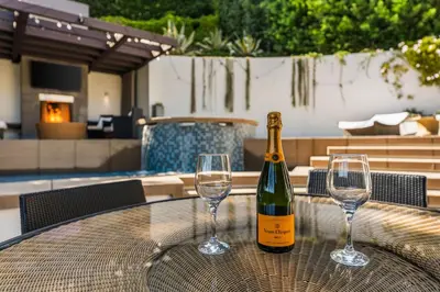 a bottle of wine sitting on a table with two wine glasses at West Hollywood Hills Jacuzzi and Beautiful View in Los Angeles