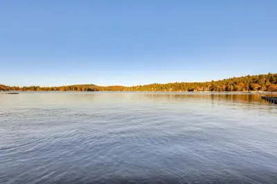 a large lake with a dock in the middle at Lake Arrowhead Hideaway with Deck and Hot Tub in Lake Arrowhead