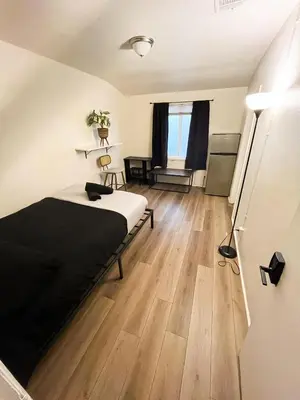a bedroom with a bed and a wooden floor at Van Nuys Homes for the Soul in Los Angeles