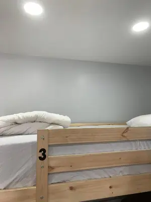 a wooden bed with white sheets and white pillows at Van Nuys Homes for the Soul in Los Angeles