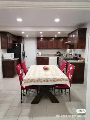a kitchen with a table with red chairs and a kitchen with a refrigerator at Home sweet home in Rowland Heights