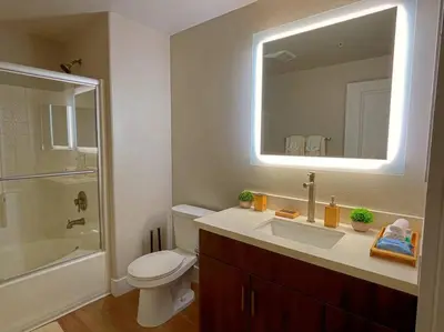 a bathroom with a sink and a toilet and a mirror at Cozy 2 Bedroom 2 Bathroom Condo with Pool, Gym, Spa in Los Angeles