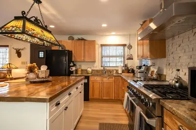 a kitchen with wooden cabinets and a stove top oven at 37 - Foxy Farm Ranch home in Big Bear Lake