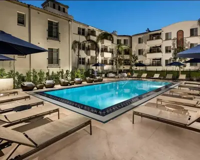 a large swimming pool with chairs and a building at Marina del Rey 2BR - Near LAX, Beach & Dining in Los Angeles