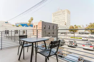 a table and chairs on a balcony with a view of a city at Blueground Long Beach pool gym nr groceries LAX-1256 in Los Angeles