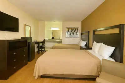 a hotel room with two beds and a desk at Casa Blanca Hotel - Azusa, Los Angeles in Azusa