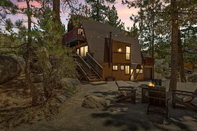 a cabin in the woods with a deck and stairs at Larks Nest in Big Bear Lake in Big Bear Lake