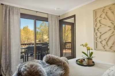 a bedroom with a bed and a view of a balcony at Larks Nest in Big Bear Lake in Big Bear Lake