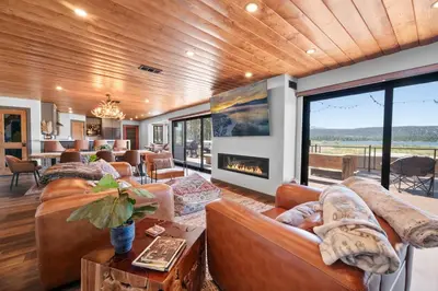a living room with leather furniture and a fireplace at The Lazy Bear - Indulge in breathtaking views of the expansive lake from this charming cabin. in Fawnskin