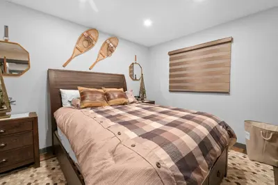 a bedroom with a bed with a checkered blanket at The Lazy Bear - Indulge in breathtaking views of the expansive lake from this charming cabin. in Fawnskin