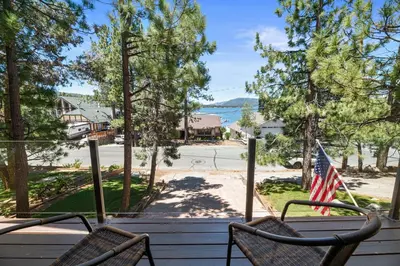 a porch with two chairs and an american flag at Sunset Spectacular - Multi-level haven with water views! Incredible for 4th of July! in Big Bear Lake