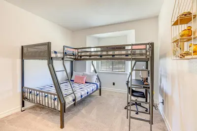 a bedroom with two bunk beds and a desk at Hesperia Home Near Mojave River and Hiking Trails! in Hesperia