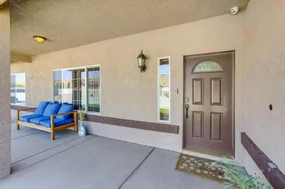 a porch with a blue couch and a door at Hesperia Home Near Mojave River and Hiking Trails! in Hesperia