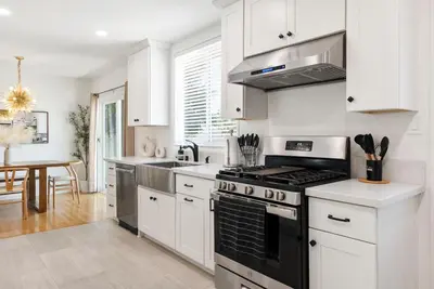 a kitchen with white cabinets and a stove top oven at Spacious 3BR Home Near Disneyland & Knotts Berry Farm in Fullerton