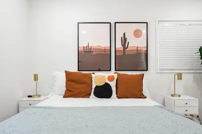 a white bedroom with a bed with orange pillows at Spacious 3BR Home Near Disneyland & Knotts Berry Farm in Fullerton