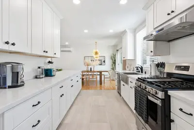 a kitchen with white cabinets and a stove top oven at Spacious 3BR Home Near Disneyland & Knotts Berry Farm in Fullerton