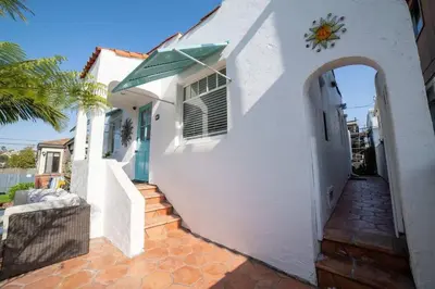 a white house with an archway next to a porch at Sea View, Flower Garden, AC, WD, Renovated in Hermosa Beach