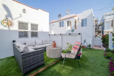 a backyard with a couch and a table and chairs at Sea View, Flower Garden, AC, WD, Renovated in Hermosa Beach